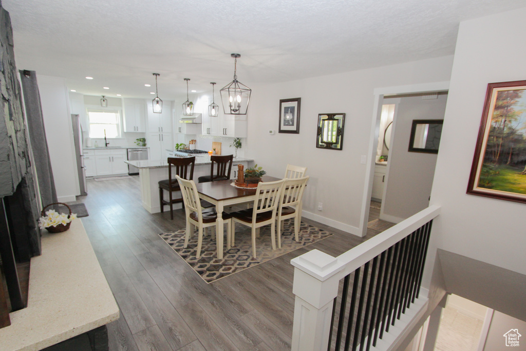Dining area with recessed lighting, wood finished floors, a fireplace, and baseboards