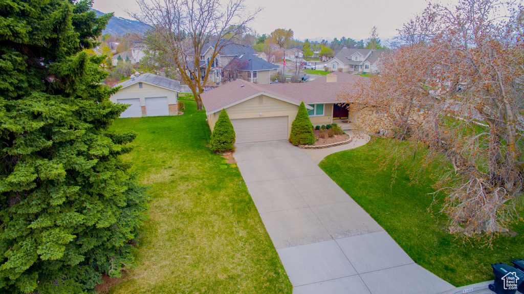 View of front of house featuring a front lawn, a residential view, and concrete driveway