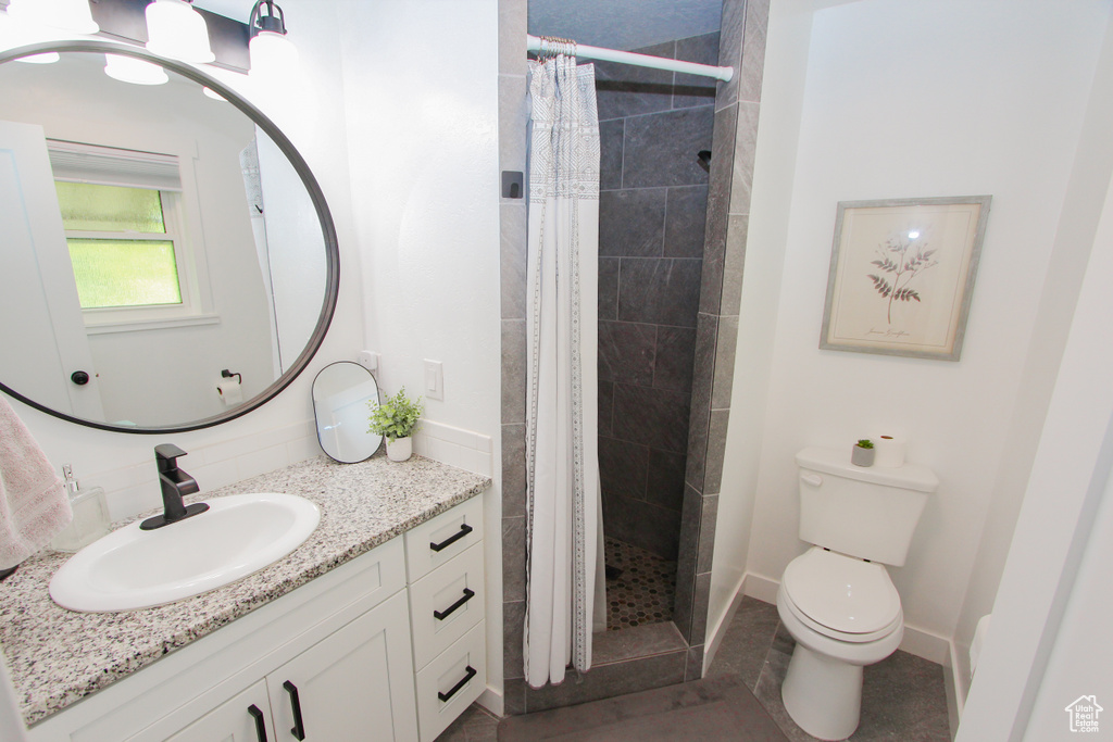 Full bath with vanity, toilet, a shower stall, and tile patterned floors