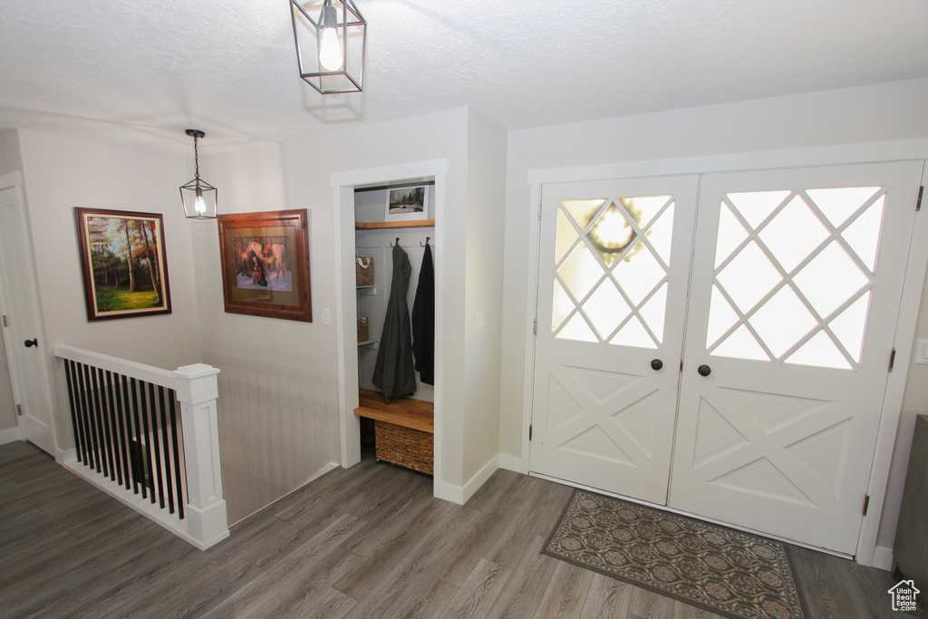 Foyer with wood finished floors, baseboards, and a textured ceiling