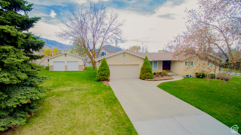 Ranch-style home featuring a front lawn, a mountain view, and a chimney