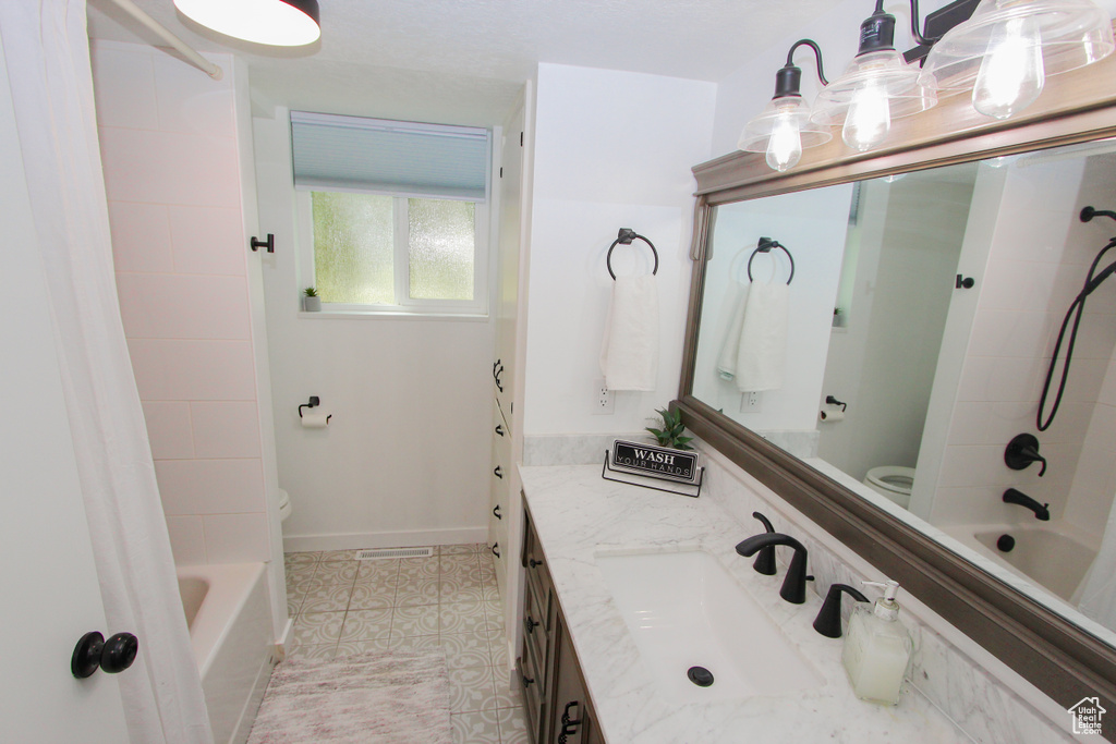 Bathroom with toilet, vanity, shower / washtub combination, and tile patterned floors