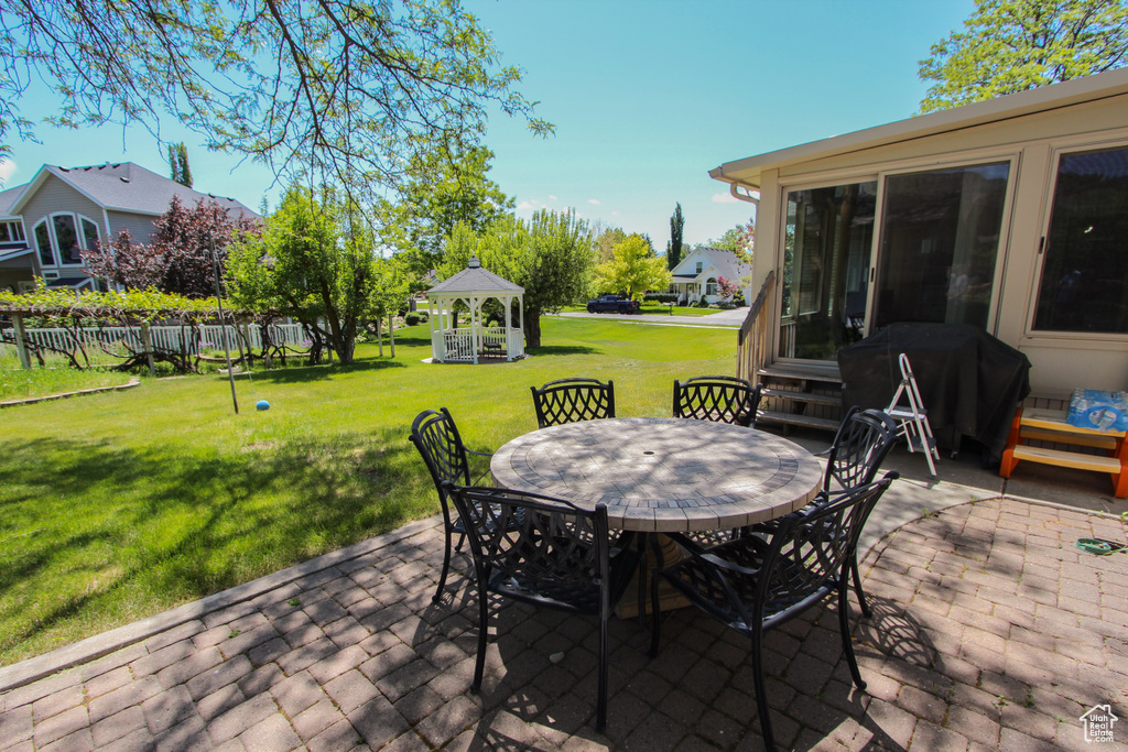 View of patio featuring outdoor dining area, a grill, and entry steps