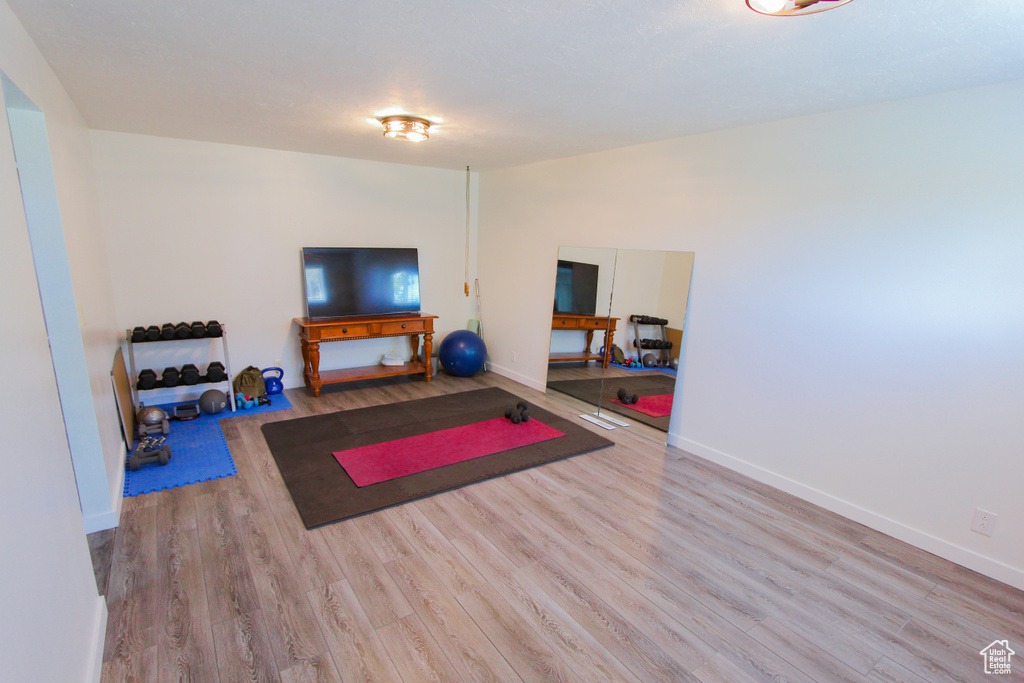 Workout area featuring wood finished floors and baseboards