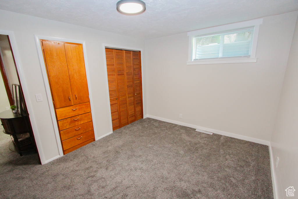Unfurnished bedroom with carpet, a closet, and baseboards