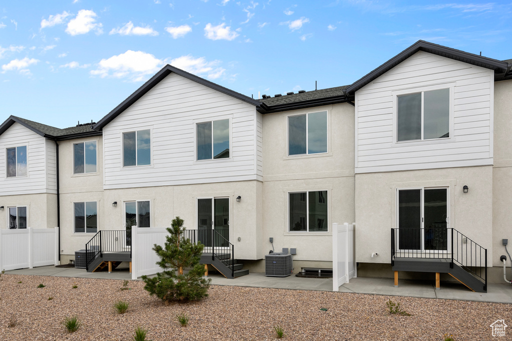 Back of property with stucco siding, a patio, and cooling unit