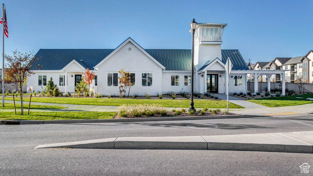 View of front of property featuring a front lawn and metal roof