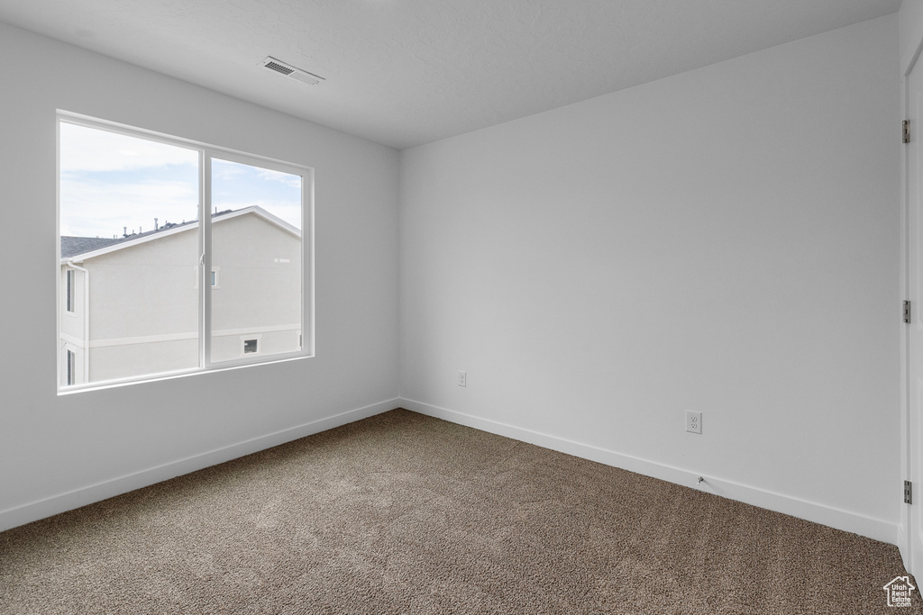 Carpeted empty room featuring baseboards