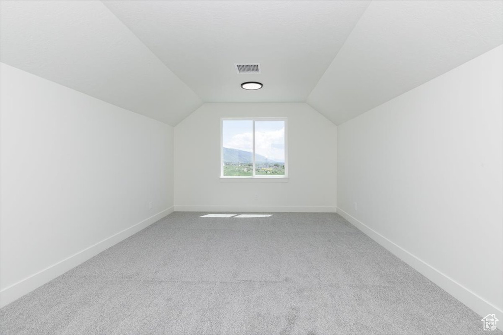 Bonus room featuring carpet floors, vaulted ceiling, and baseboards