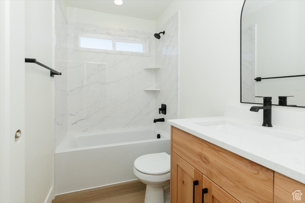 Bathroom featuring vanity,  shower combination, toilet, and wood finished floors