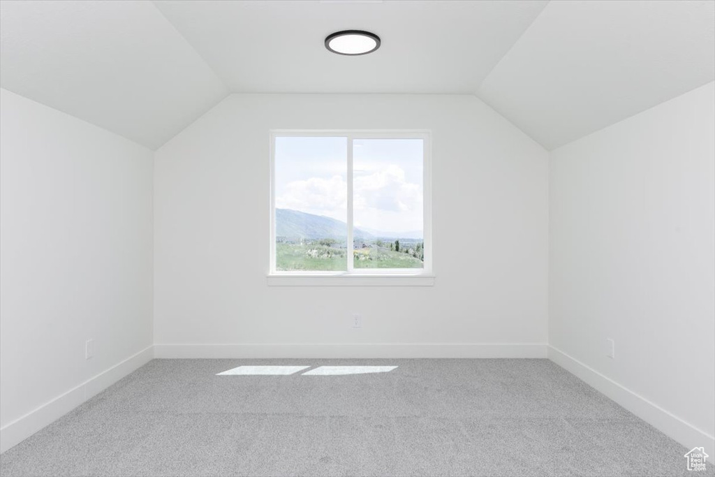 Bonus room featuring vaulted ceiling, carpet, and baseboards