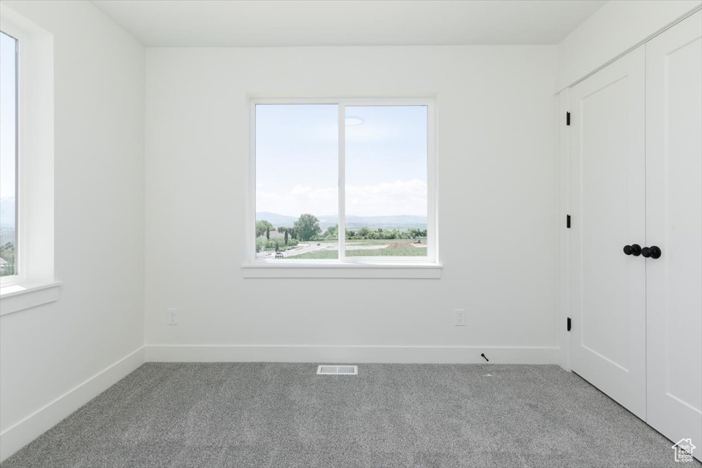 Unfurnished bedroom with carpet flooring, baseboards, and multiple windows
