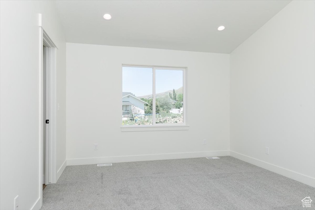 Empty room with light carpet, baseboards, and recessed lighting