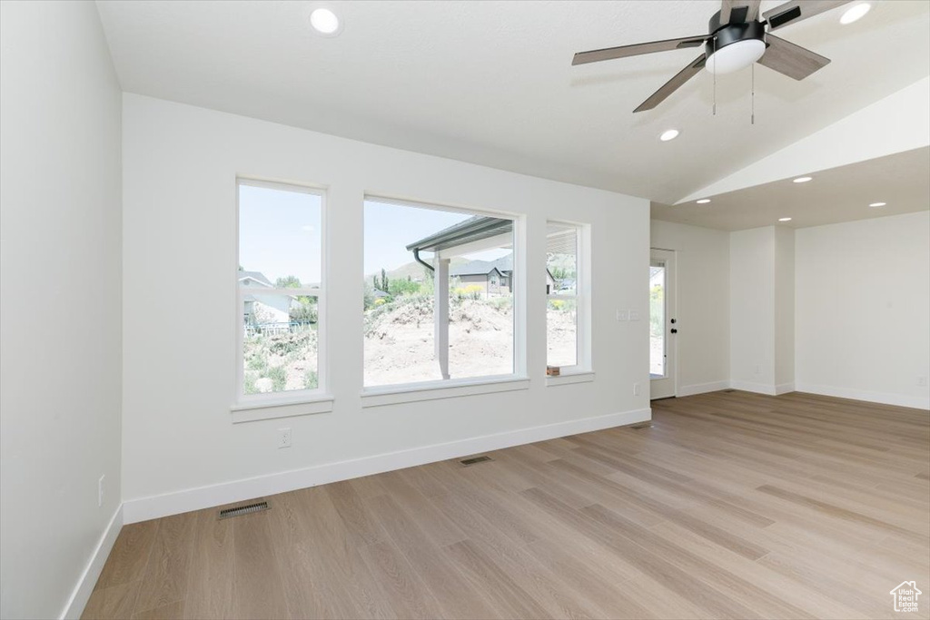 Unfurnished living room with light wood-style flooring, recessed lighting, baseboards, vaulted ceiling, and a ceiling fan