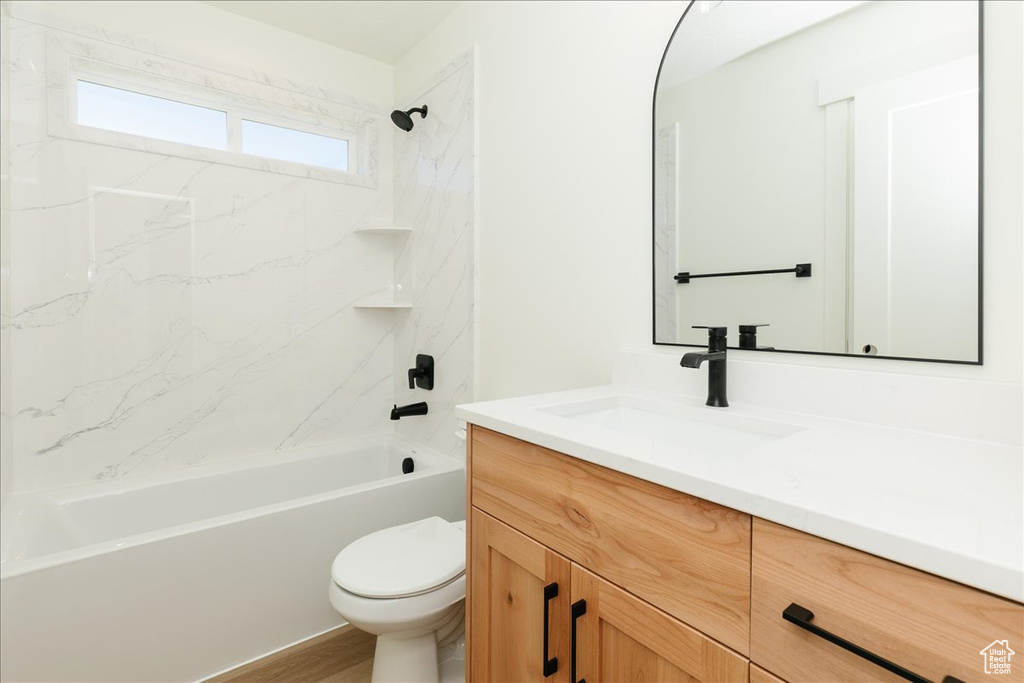Full bathroom featuring vanity, bathing tub / shower combination, toilet, and wood finished floors