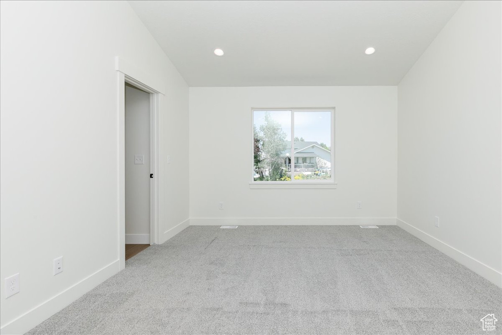 Spare room featuring carpet floors, baseboards, and recessed lighting
