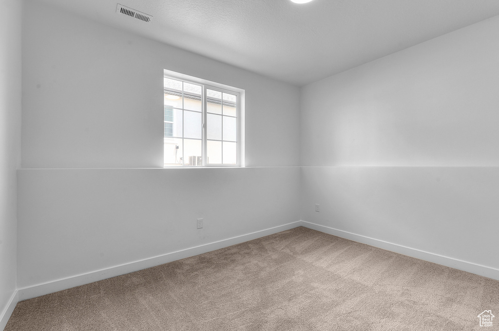 Spare room with carpet and baseboards