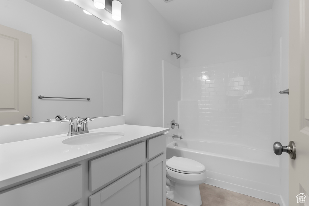 Bathroom with vanity, toilet, bathtub / shower combination, and tile patterned floors