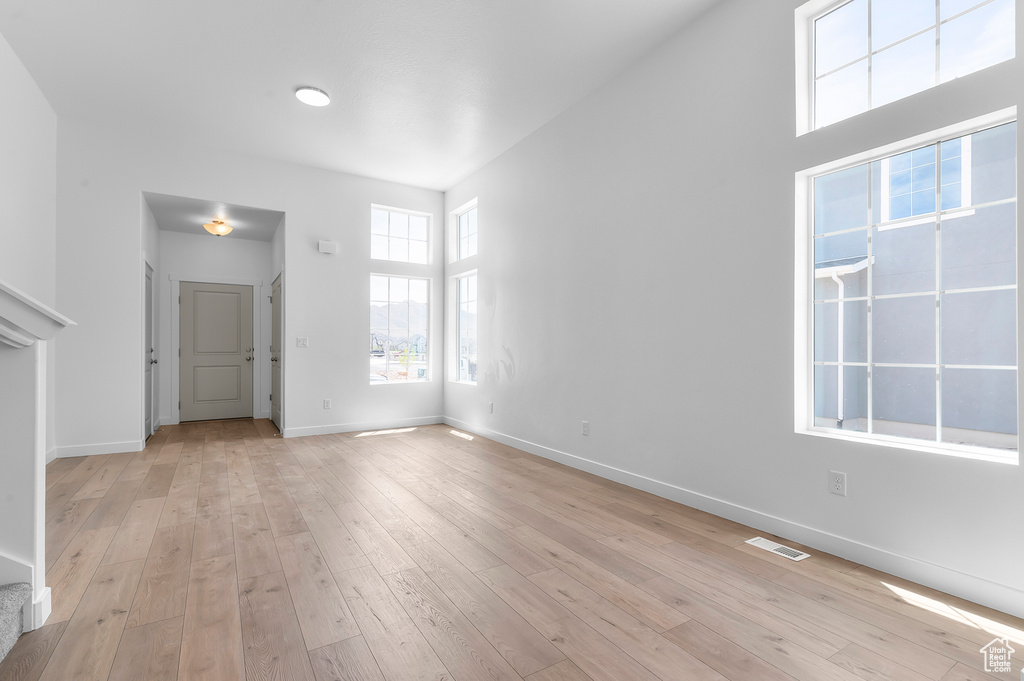 Unfurnished living room with baseboards and light wood-type flooring