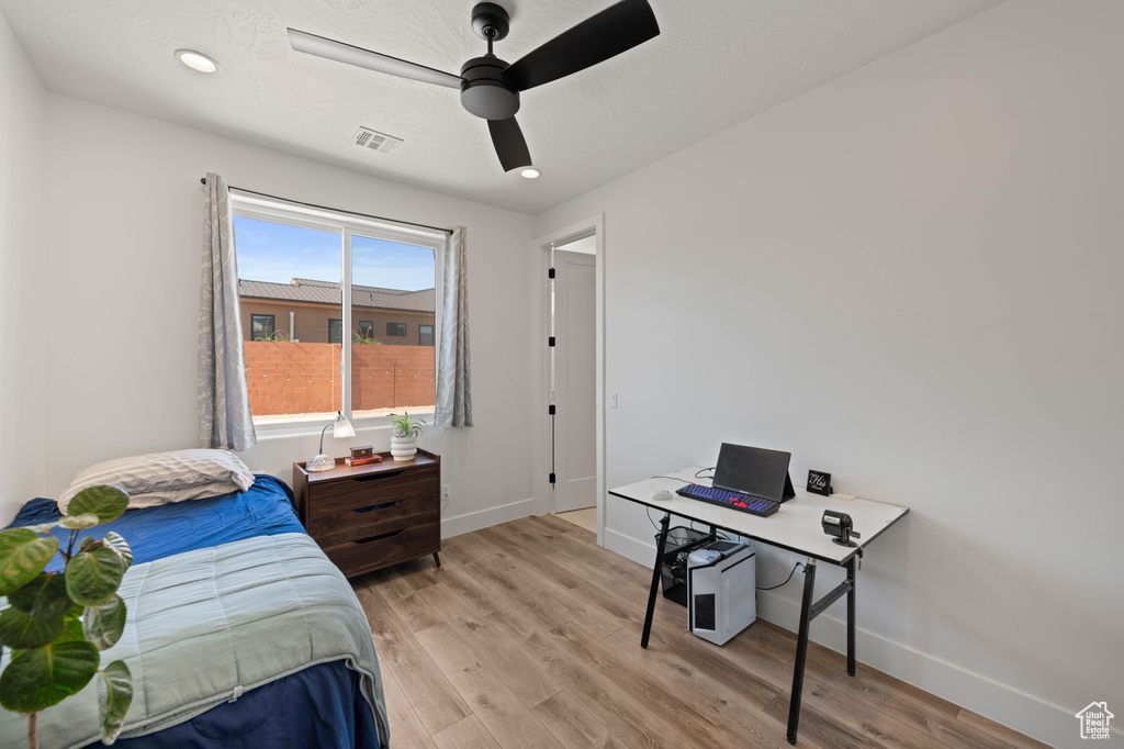 Bedroom featuring baseboards, light wood-style floors, and a ceiling fan