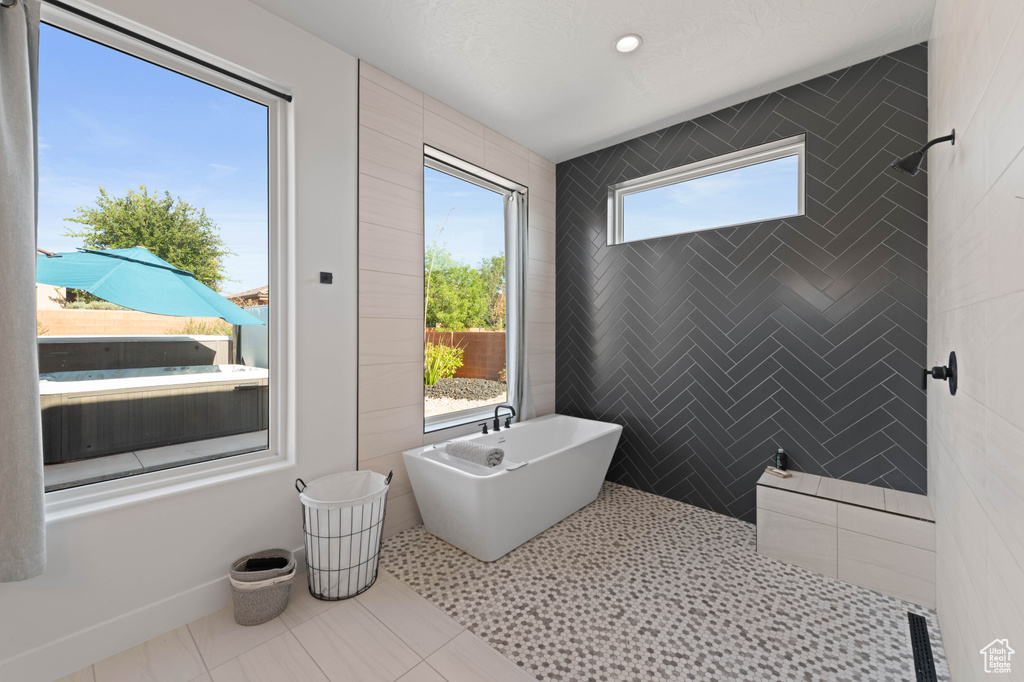 Full bathroom with a freestanding bath and tile patterned floors