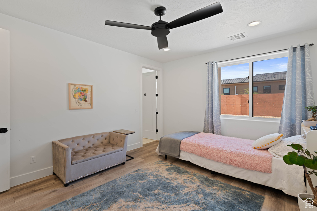 Bedroom with baseboards, wood finished floors, ceiling fan, and recessed lighting