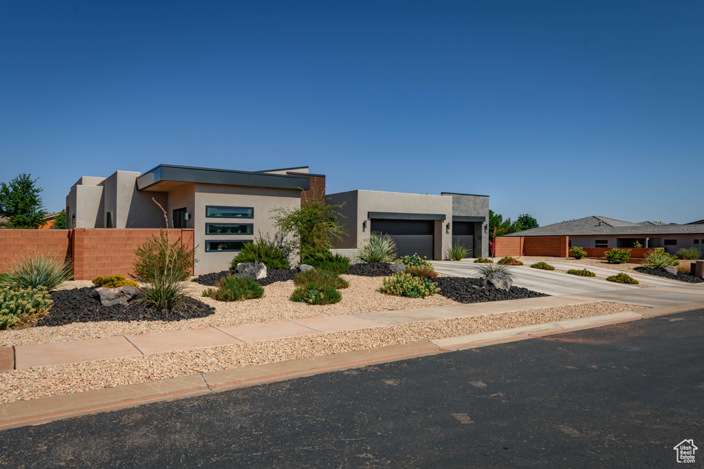 Modern home featuring stucco siding, a garage, and concrete driveway