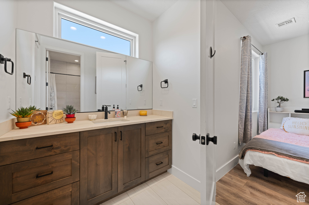Full bath featuring vanity, baseboards, wood finished floors, ensuite bath, and curtained shower