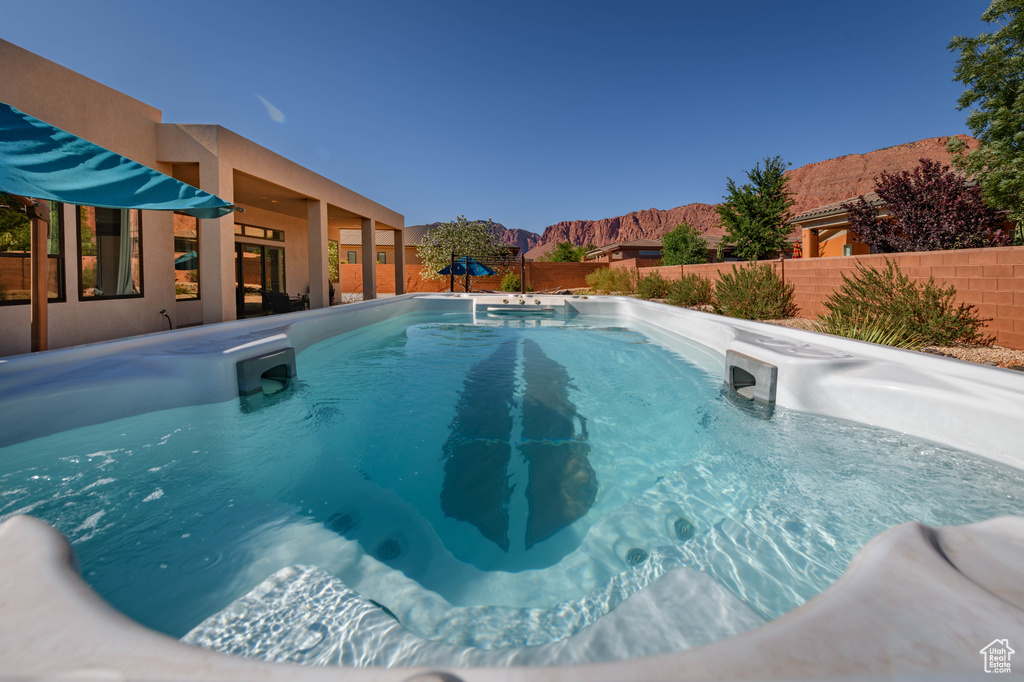 View of swimming pool with a fenced backyard, a swimming pool, and a mountain view