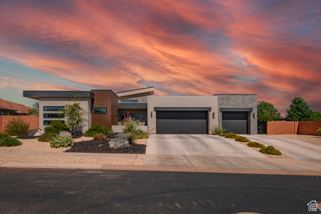 Contemporary home featuring a garage, concrete driveway, and stucco siding