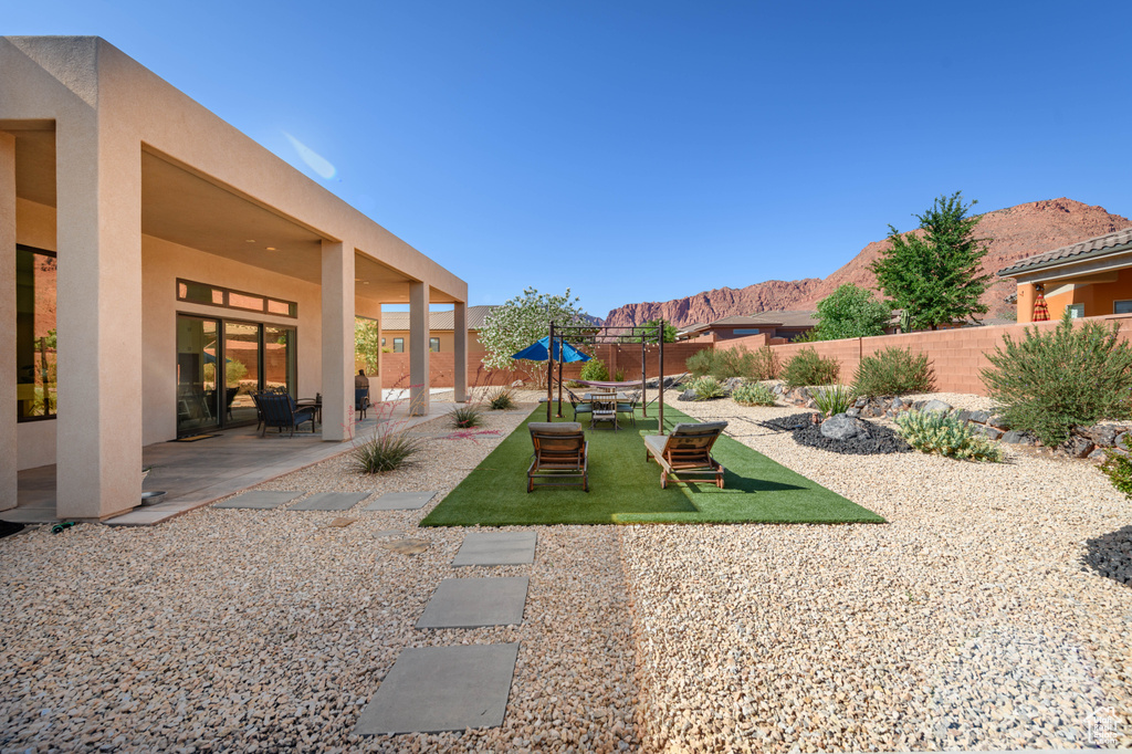 Fenced backyard featuring a mountain view and a patio area