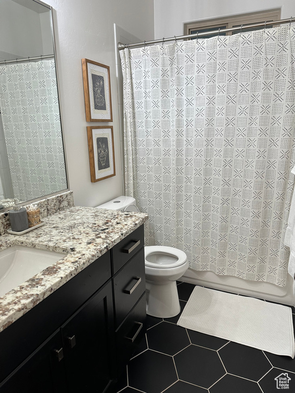 Full bath featuring vanity, toilet, and tile patterned floors