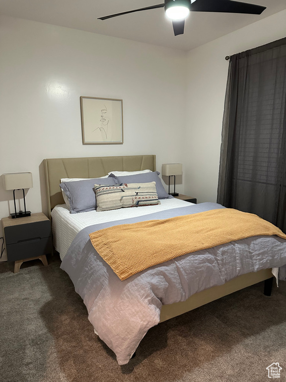 Carpeted bedroom with a ceiling fan
