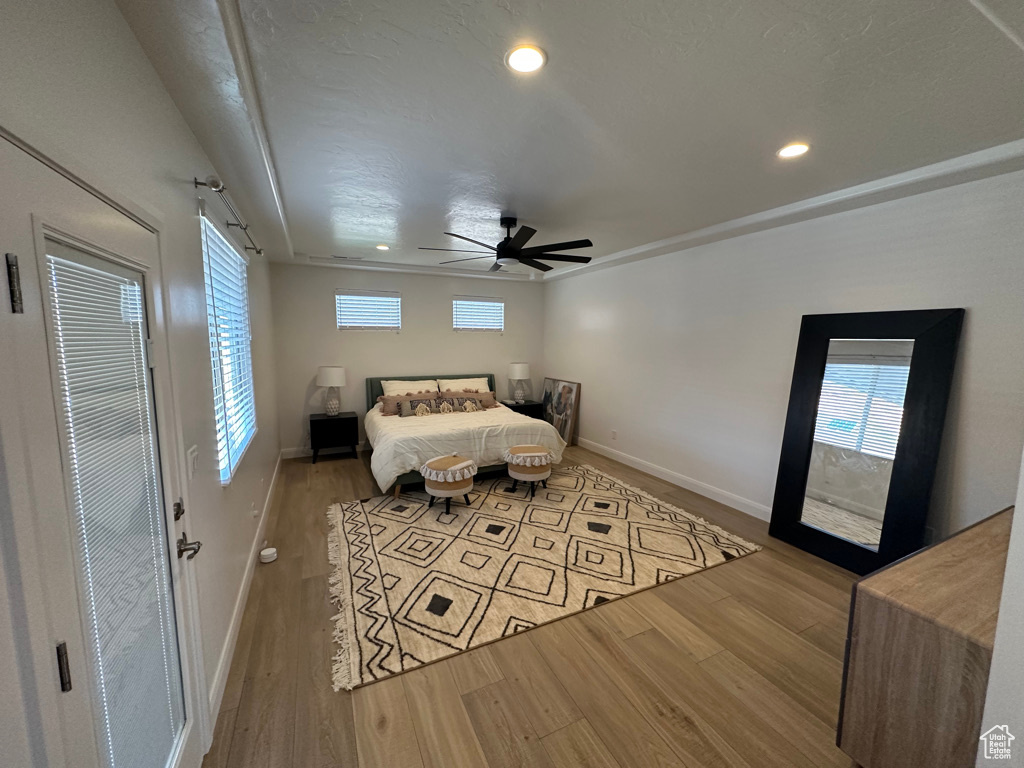 Bedroom featuring wood finished floors, baseboards, multiple windows, and recessed lighting