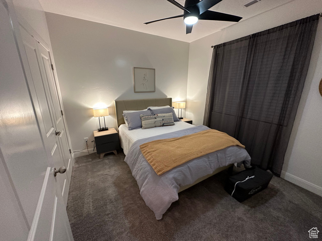 Carpeted bedroom featuring baseboards and a ceiling fan