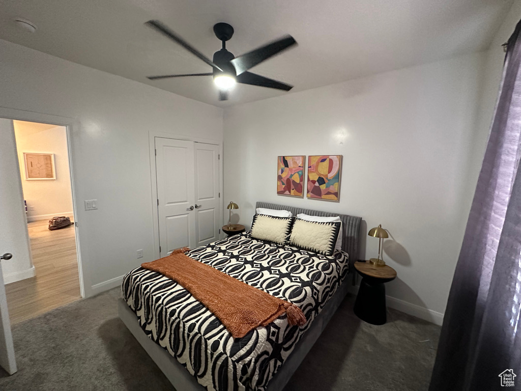 Bedroom featuring carpet floors, a closet, baseboards, and a ceiling fan