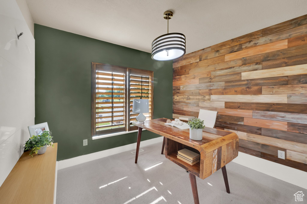 Home office featuring wood walls, carpet flooring, and baseboards