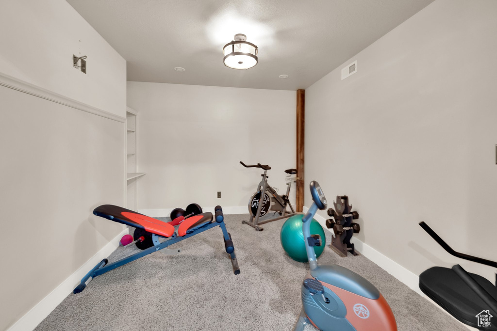 Exercise room featuring baseboards and carpet flooring