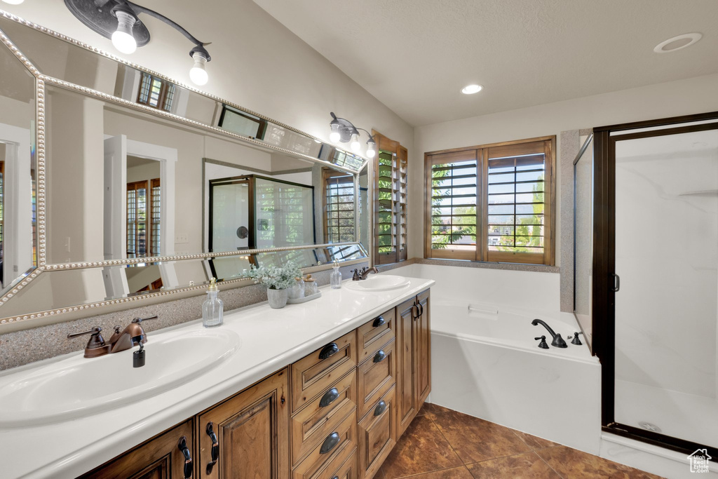 Bathroom with a shower stall, double vanity, a bath, and recessed lighting