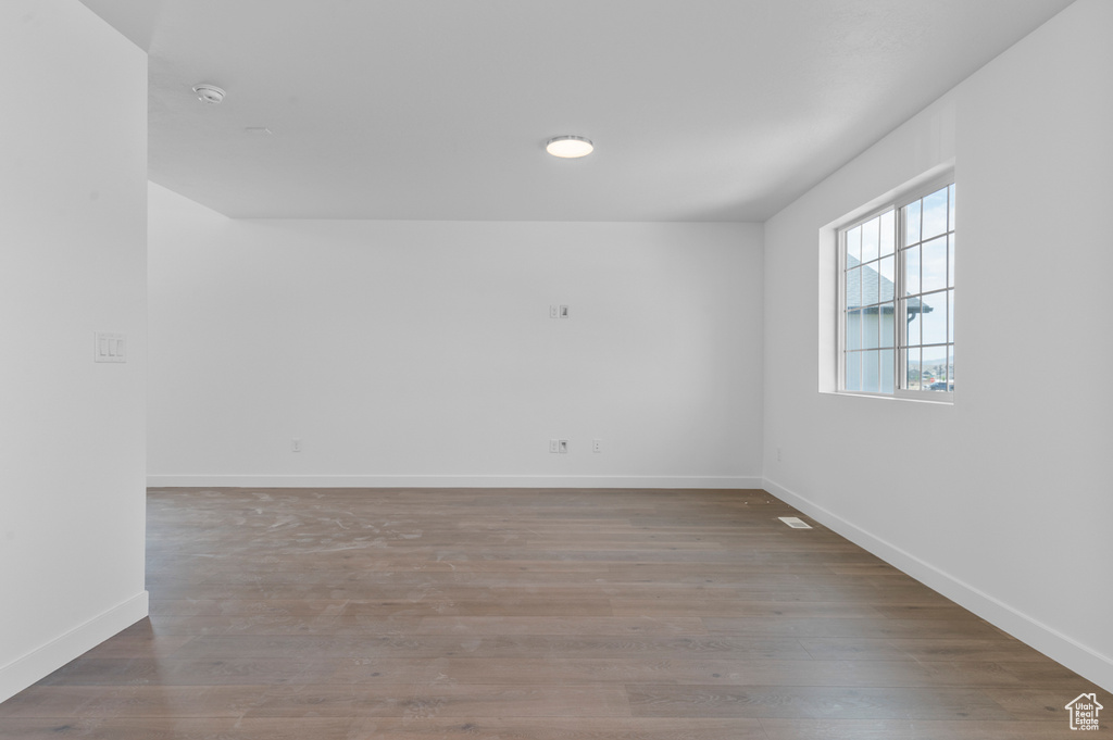 Unfurnished room with baseboards and wood finished floors