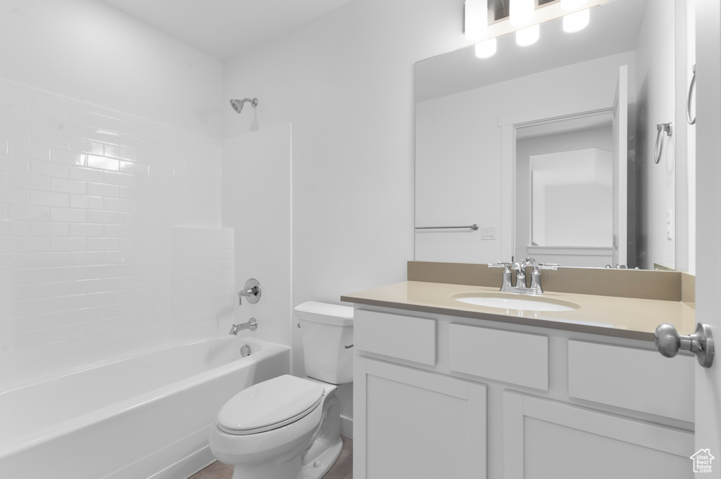 Bathroom featuring toilet, vanity, and shower / tub combination