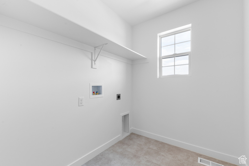 Laundry area with hookup for a washing machine, baseboards, hookup for an electric dryer, and light carpet