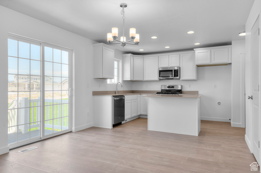 Kitchen featuring appliances with stainless steel finishes, baseboards, a chandelier, recessed lighting, and a sink