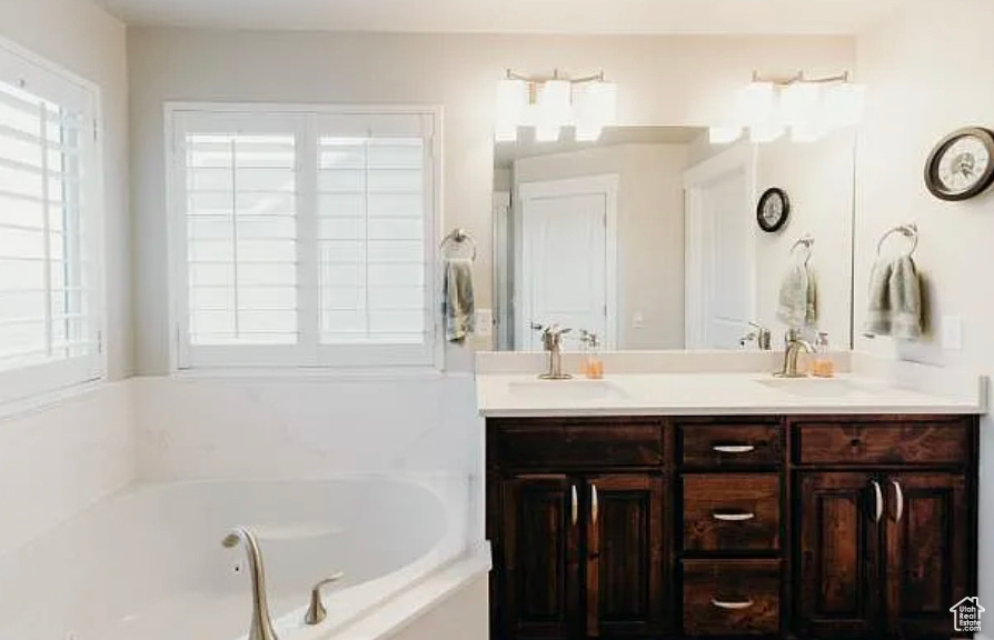 Full bathroom featuring a tub with jets and double vanity