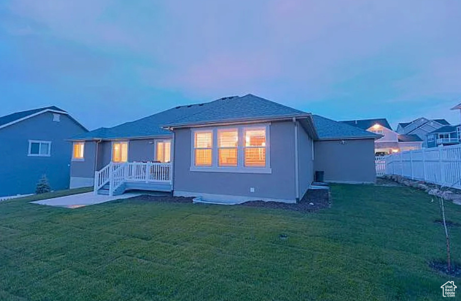 Back of house at dusk with stucco siding