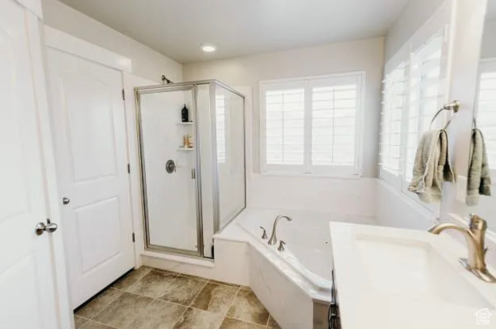 Full bathroom with a shower stall, a bath, and vanity