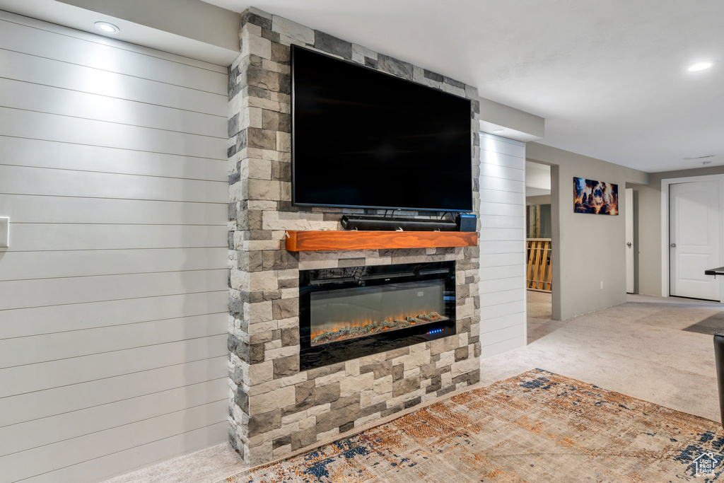 Unfurnished living room with a stone fireplace, carpet, and recessed lighting
