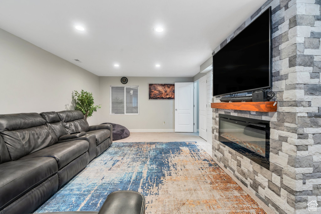 Living area featuring recessed lighting, baseboards, a stone fireplace, and carpet