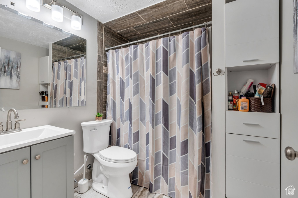 Full bath featuring vanity, toilet, and a shower with shower curtain