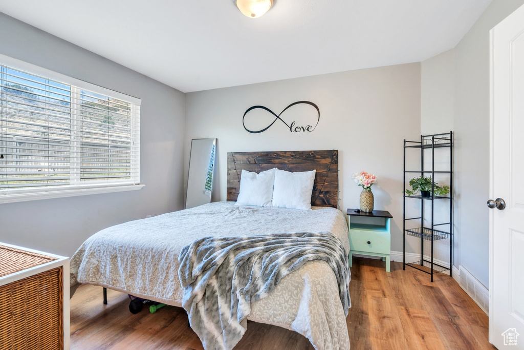 Bedroom with wood finished floors and baseboards